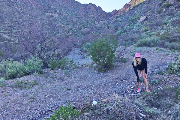 Woman picking up trash from trail